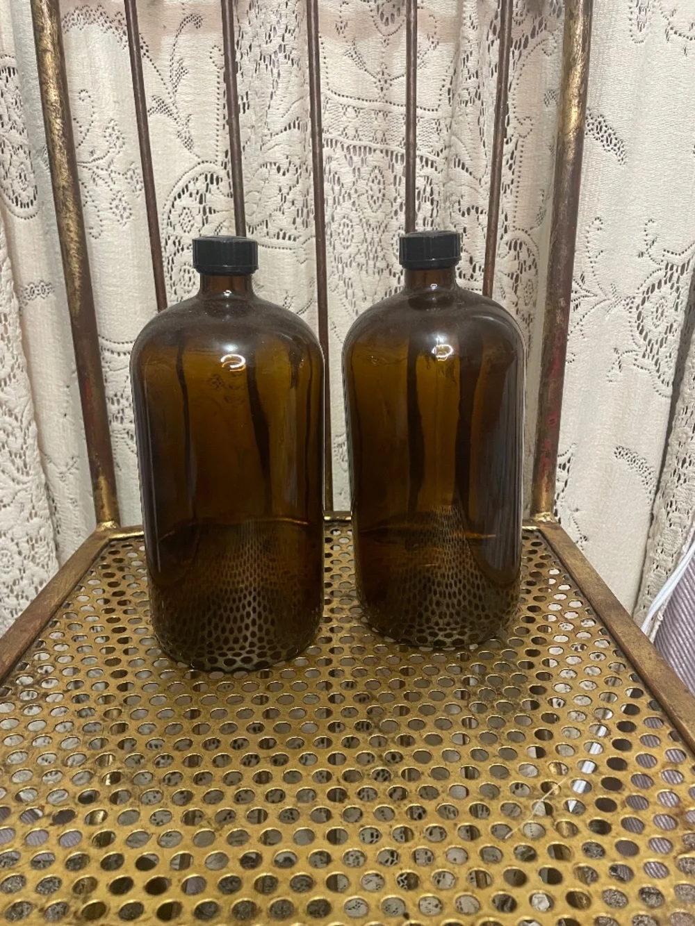 two amber glass Boston round bottles with black caps
